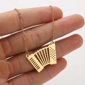 Vue détaillée d'un pendentif accordéon doré vintage sur une fine chaîne à maillons dorés
