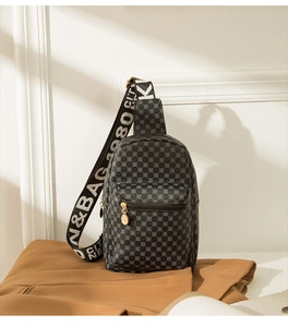 Detail of crossbody chest bag featuring circle patterns and wide lettered strap
