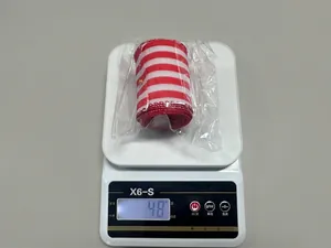 Dettaglio di un nastro a quadri rosso e bianco del peso di 48g sulla bilancia