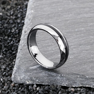 Dettaglio dell'anello in tungsteno con taglio a diamante su sfondo di pietra