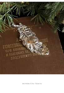 Macro detail of transparent acrylic feather ornament with gold sequins for Christmas decor