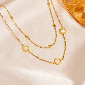 Close-up of double-layered titanium gold necklace with Roman dial and shell inlays