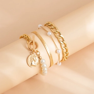 Detailed view of a 4-piece vintage gold bracelet set with pearls and a coin charm