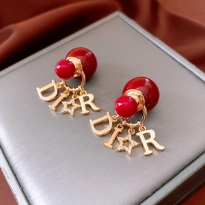 Detail showing 18K gold-plated double pearl earrings with red bead and metal charms