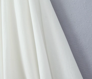 Gros plan du tissu blanc à manches bouffantes avec plis élégants et texture douce