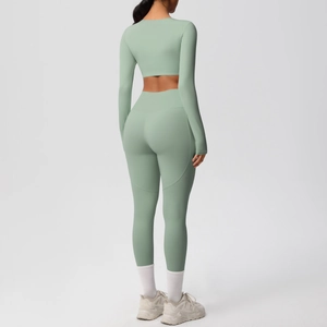 Sage green yoga set featuring a long sleeve crop top and high waist leggings from behind
