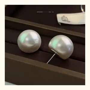 Close-up of premium oversized pearl earrings with iridescent luster on a velvet box