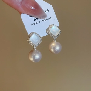 Detail of silver flower stud earrings with purple pearl and sparkling crystal accents