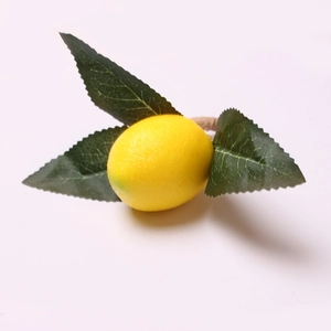 Realistic artificial lemon napkin ring with vibrant yellow fruit and green leaves on white background