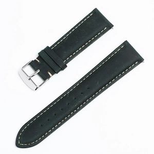 Detail shot of a dark green leather watch strap with beige stitching and silver buckle