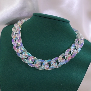 Chunky colorful acrylic link chain necklace with iridescent finish on green model bust