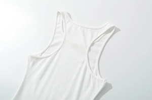 Detailed view of the neckline and knitted texture of a white sleeveless dress