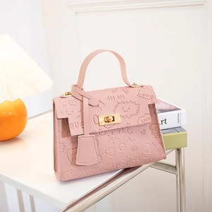 Detail of pink embossed pattern bag with sun and cloud motifs and gold twist lock