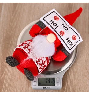 Digital scale showing Christmas gnome weight of 141.6g on a rustic wooden background