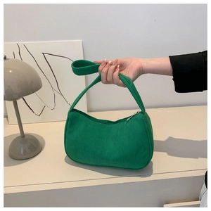 Detail of green corduroy baguette bag showing soft texture and sturdy top handle strap