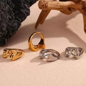 Artistic gold and silver rings with abstract shapes on peach textured surface