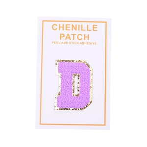 Macro detail of purple chenille letter D patch with gold sequins and adhesive backing