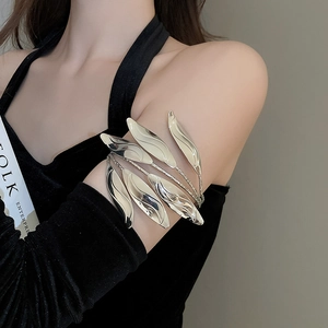 Detailed view of silver leaf-shaped upper arm cuff with polished metallic mirror finish