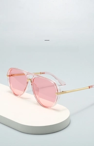 Detail of pink gradient lenses and gold metal temples on oversized aviator sunglasses