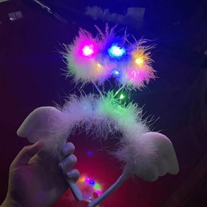 Close-up of LED headband with glowing colorful lights and soft white feathers in the dark