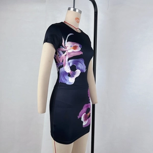 Détail d'une robe moulante noire avec imprimé orchidée violette et coupe ajustée