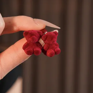 Chic red velvet teddy bear stud earrings featuring a soft flocked texture and silver pins