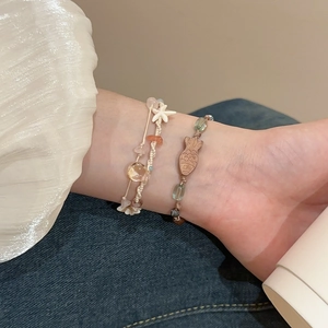 Detail eines Boho-Armbands mit Seestern-Anhängern und bunten Perlen am Handgelenk