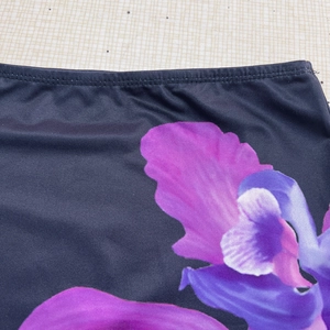 Détail du tissu à fleurs montrant des coutures doubles haute densité sur maille marine