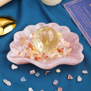 Pink quartz shell bowl with yellow crystal sphere and tumble stones for home decor