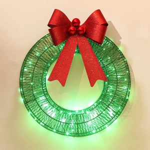 Close-up of green LED Christmas wreath with a large sparkling red bow and glowing lights