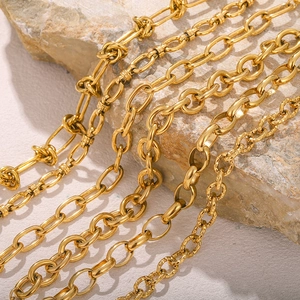 Macro shot of various 18k gold plated stainless steel link chains on natural stone