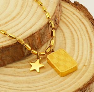 Détail macro du collier doré en acier inoxydable avec pendentif carré et étoile