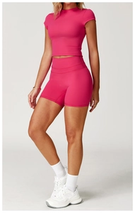 Dettaglio del top corto rosa e dei pantaloncini da ciclista a vita alta set sport