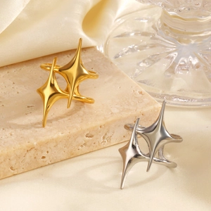 Minimalist 18K gold and silver star rings on a natural stone base with satin fabric