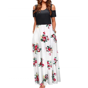Detail of cold shoulder dress featuring black top and red rose floral print on white maxi skirt