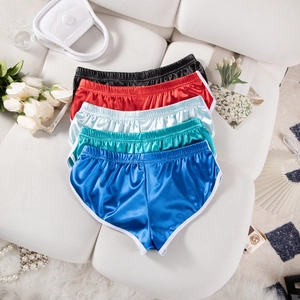 Vista piatta di pantaloncini sportivi in raso colorato con bordo a contrasto