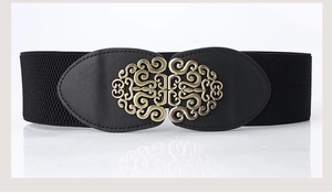 Close-up of vintage gold metallic buckle on a wide black elastic waist belt for women