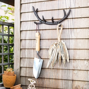 Europäischer Vintage-Geweih-Wandhaken in Dunkelbronze auf einer hellen Holzwand
