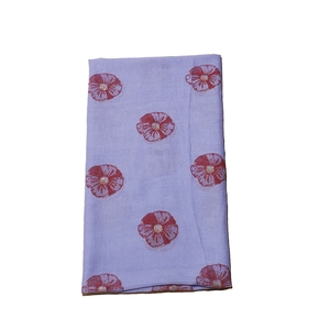 Detailed view of purple scarf fabric featuring large red floral patterns and gold accents