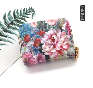 Close-up of ink red floral card holder with gold zipper and decorative green leaf