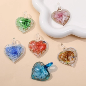 Macro shot of glass heart pendants with handmade floral patterns and gold leaf inside