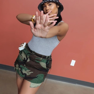 Trendiger Damen Camouflage Minirock kombiniert mit grauem Top und Ketten-Gürteltasche
