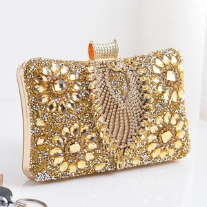 Detail of champagne gold evening clutch featuring sunflower rhinestone patterns and metal clasp