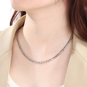Gros plan d'un collier en maille Figaro argentée porté par un mannequin en studio photo