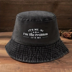 Close-up of white embroidered text on washed black cotton bucket hat with vintage texture
