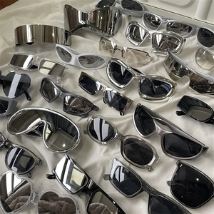 Futuristic Y2K cycling sunglasses in metallic silver and black on white fabric