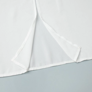 Detailed view of the side slit and neat stitching on a semi-sheer white chiffon blouse