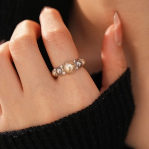 Detailed view of elegant multi-color pearl ring with zircons on gold-plated band