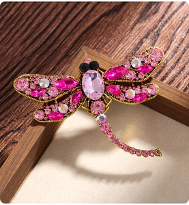 Detailed macro of vintage dragonfly brooch with pink crystals and gold-tone metal