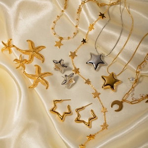 Détail de breloques étoile et lune avec perles sur fond de soie de couleur champagne